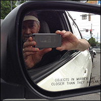 Jonathan Ochshorn in car with side mirror stating 'Objects in mirror are closer than they appear'