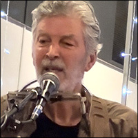 Jonathan Ochshorn playing guitar and harmonica at the Homer Center for the Arts