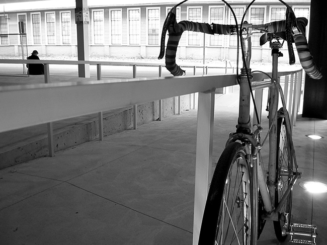 Bicycle locked up against handrail for ramp.