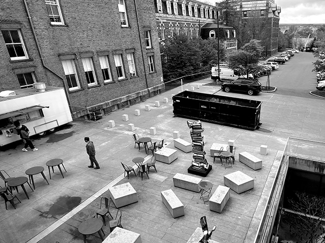 View of Milstein Hall plaza from the second floor of Milstein Hall, with the sunken garden, loading area, and parking lot visible.