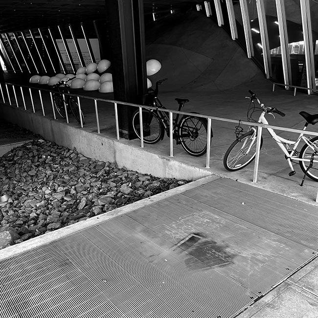 Covered space looking down at air intake grille with spray-painted markings.